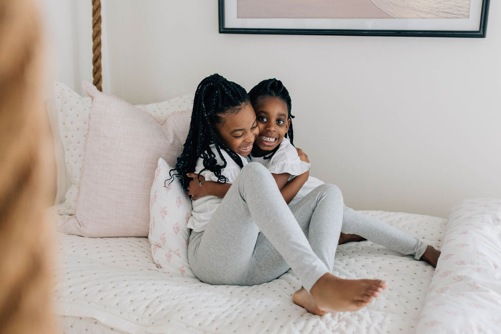 
      Girl sitting on the Bed-dys zipper bedding.
    