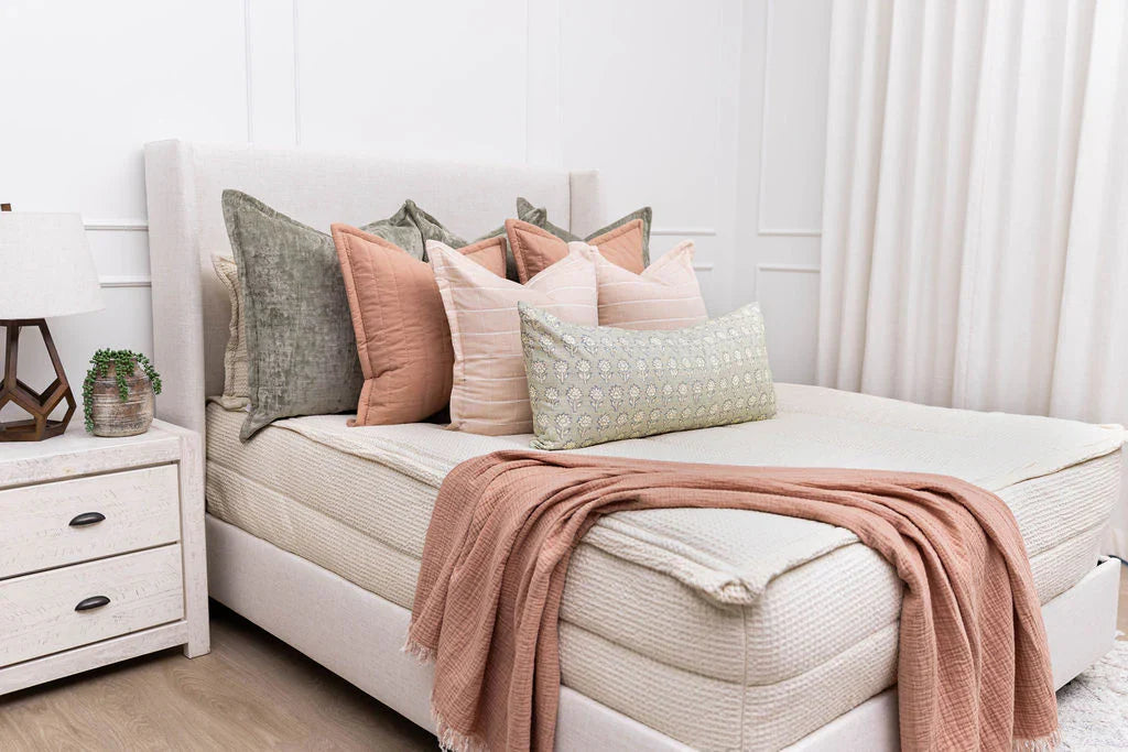 A bed made with Bed-dys cream zipper bedding and an assortment of bedding accessories.