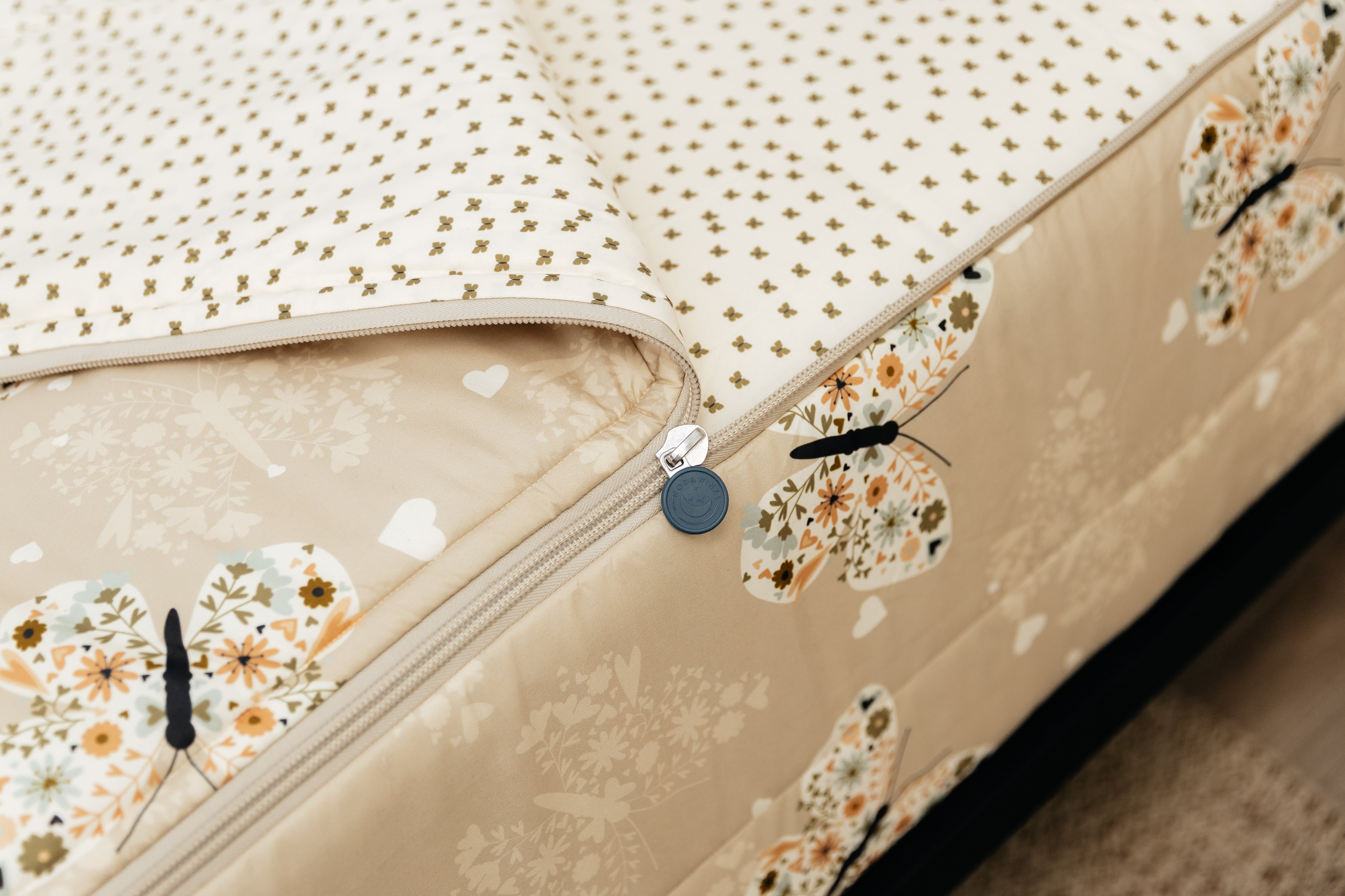 A tight shot of the zipper feature on a set of butterfly printed zipper bedding.